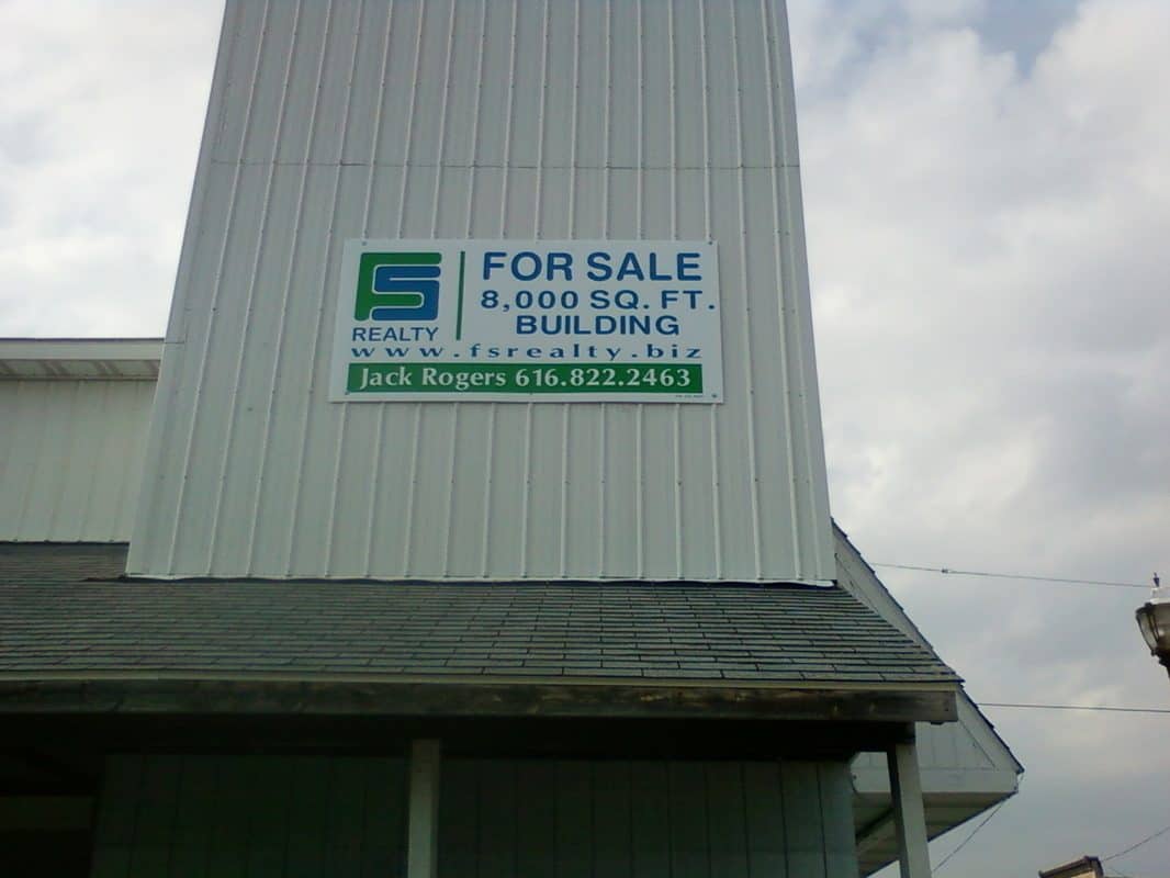 For sale sign on building advertising 8,000 sq ft space.