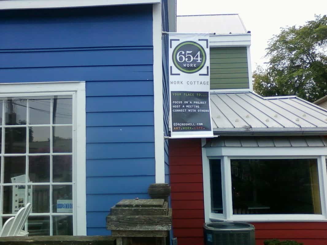 Sign for 654 Work Cottage with logo and contact info.