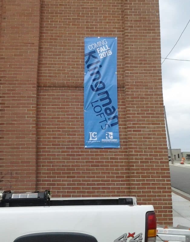 Blue banner on brick wall announcing fall 2015 event.