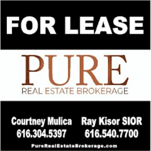 Handicap parking sign with 'For Lease' text and contact info for Pure Real Estate.
