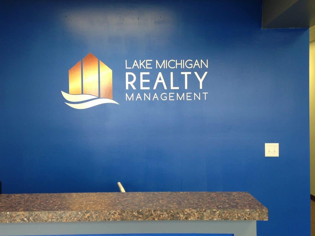 Lake Michigan Realty Management logo on blue wall with building icon.