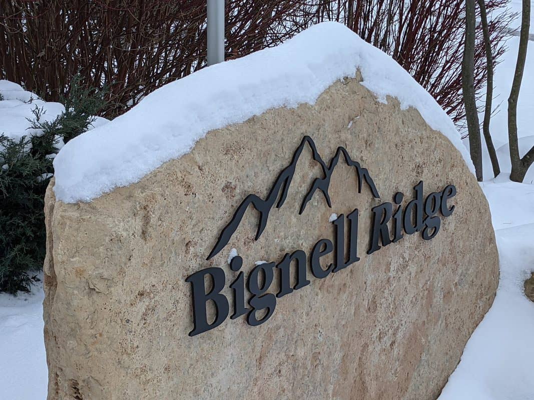 Mountain-themed Bignell Ridge sign on a snowy landscape.