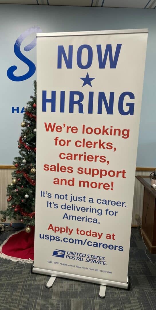 USPS Now Hiring sign for clerks, carriers, sales support, and more.