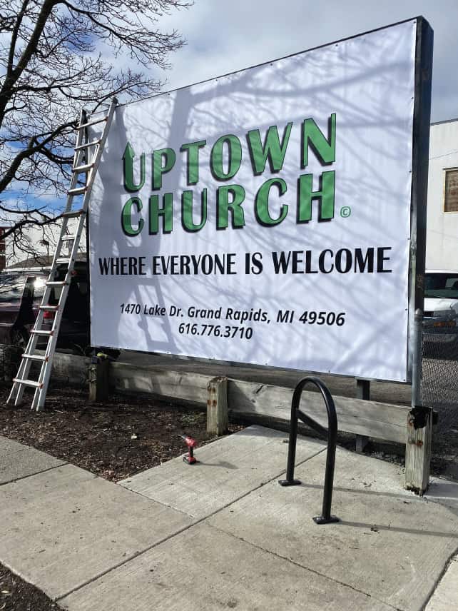 Large outdoor sign for Uptown Church with address and contact info.