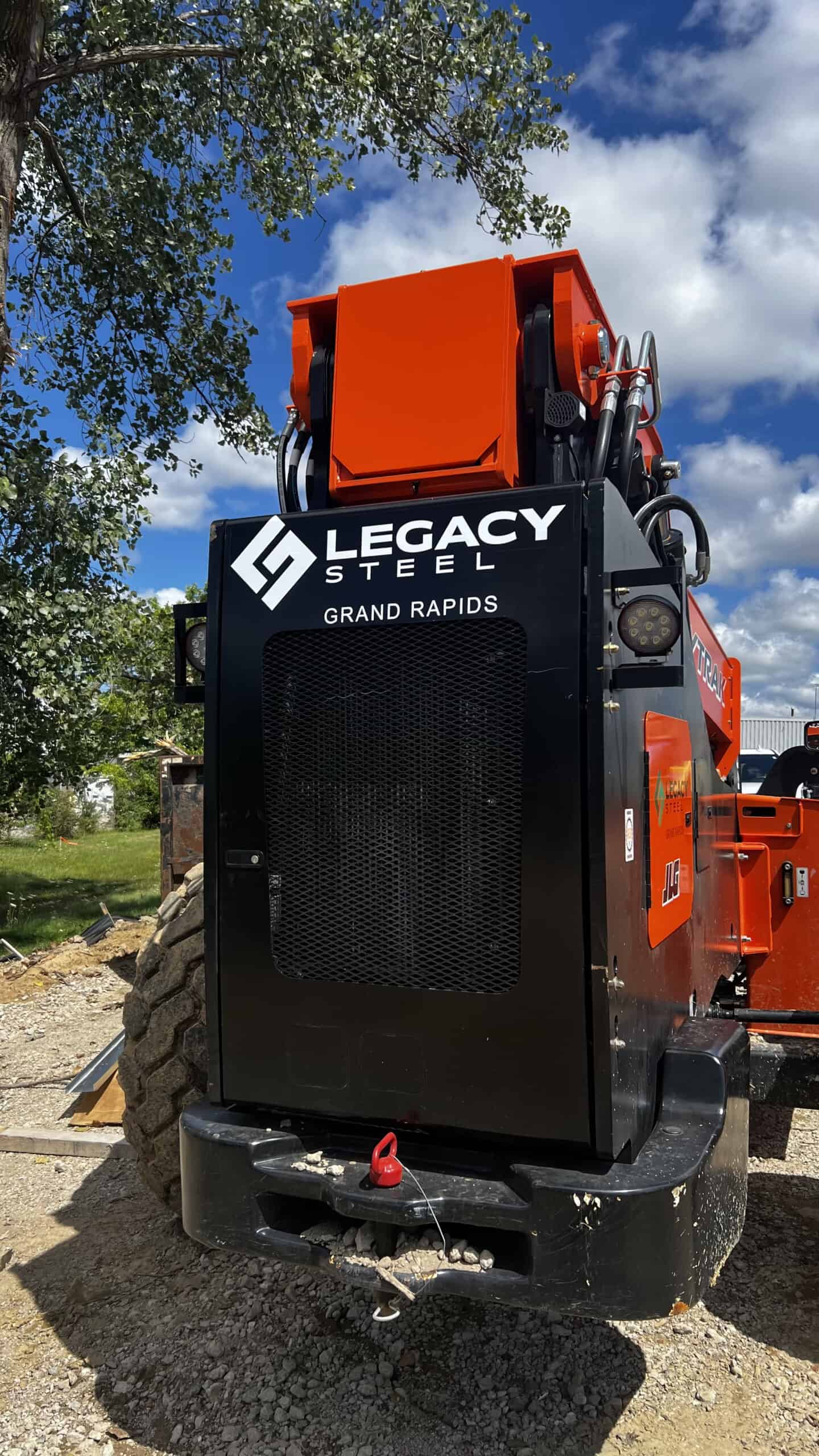 Construction equipment with Legacy Steel logo and orange parts.