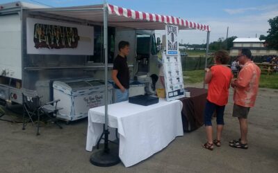 Ice Box Brand ice cream bars stand with customers at an outdoor event.