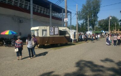 Ice cream bars on a food truck at an outdoor fair with people in line.
