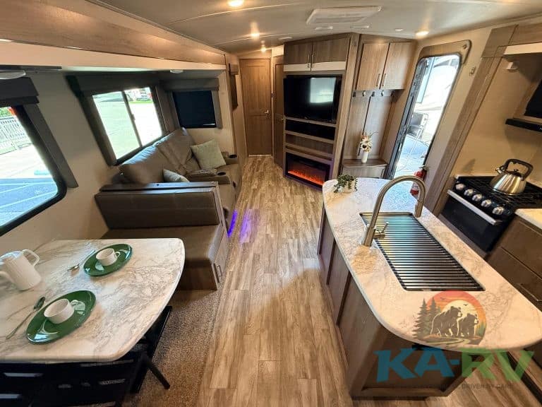 RV interior with kitchen, sofa, and entertainment center for optimal travel comfort.