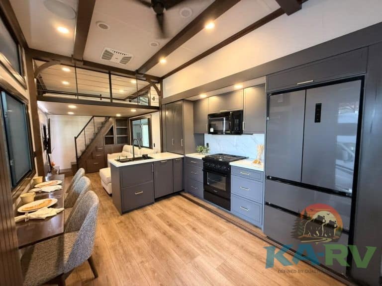 Contemporary kitchen with dark cabinets, stainless steel appliances, and wooden flooring.