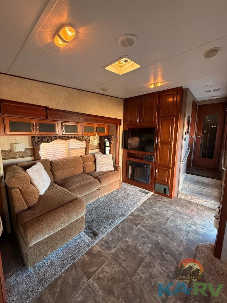RV interior with sofa, TV, and kitchen area for optimal travel comfort.