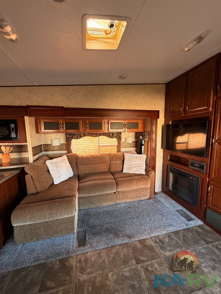 Comfortable RV living room with sofa, cabinetry, and fireplace.