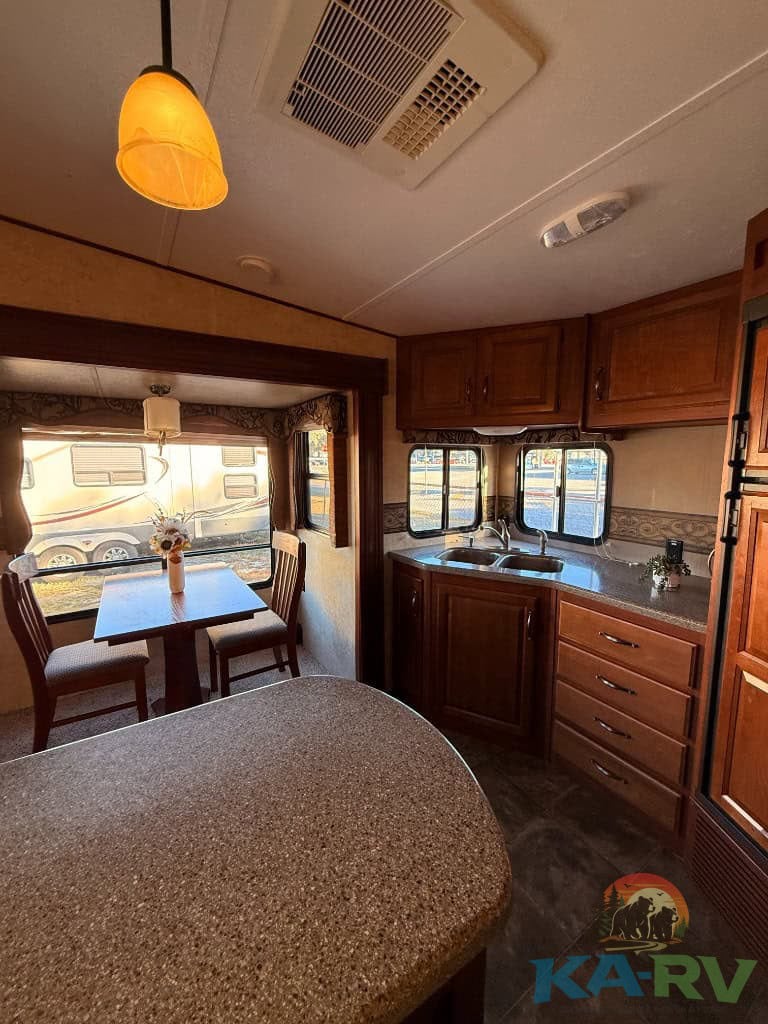 RV kitchen and dining space inside a Keystone Cougar 331MKS.