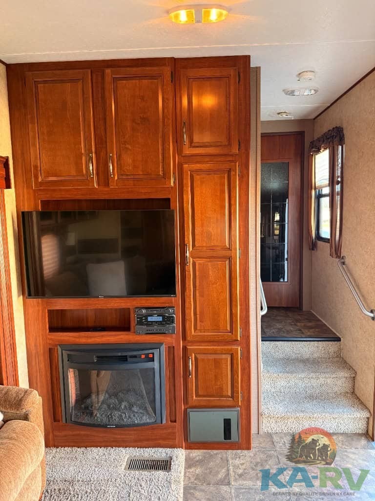 Interior view of a 2014 Keystone Cougar 331MKS with wooden cabinetry and entertainment center.