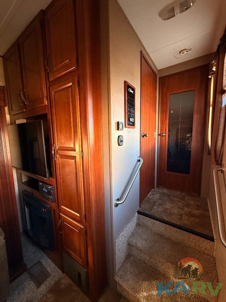 Interior view of a 2014 Keystone Cougar 331MKS RV showcasing wood cabinetry and living space.