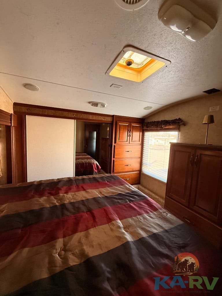 Interior of Keystone Cougar 331MKS RV showing bedroom and storage cabinets.