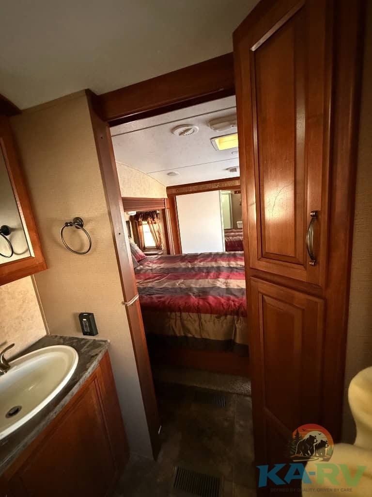 Interior view of a 2014 Keystone Cougar 331MKS RV bedroom and bathroom area.