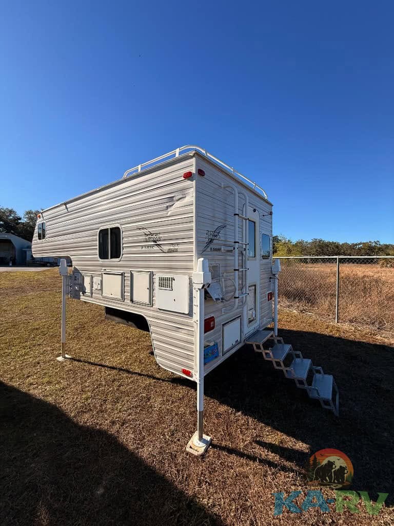 RV trailer with slide-out and stairs for camping or travel.