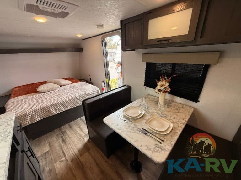 Interior view of Keystone Colorado 17RBC RV with dining and sleeping area.