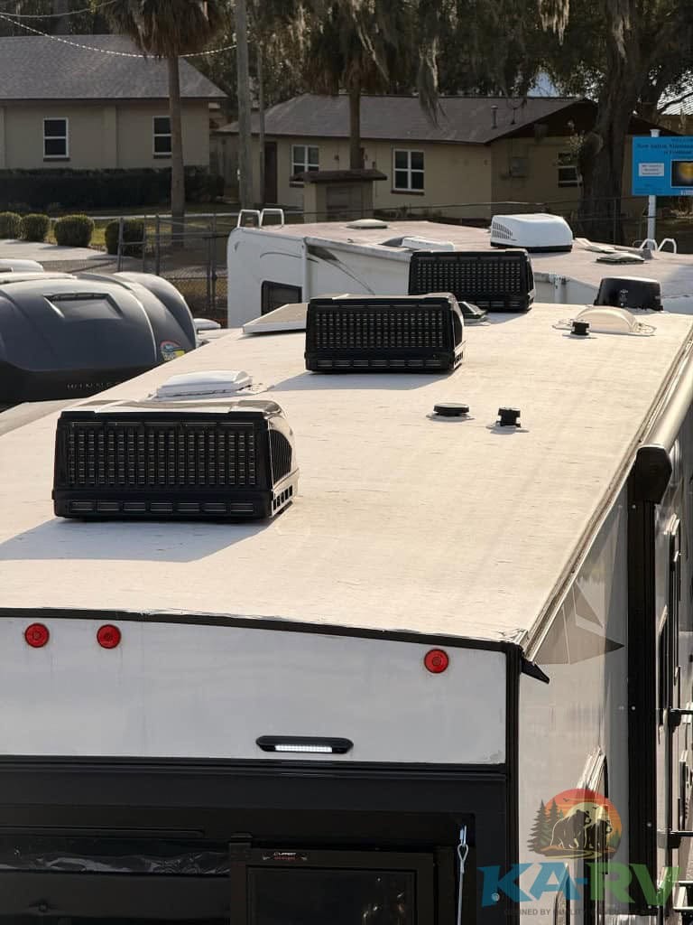 Rooftop solar air conditioners on Dutchmen Voltage 3800 RV for efficient cooling.