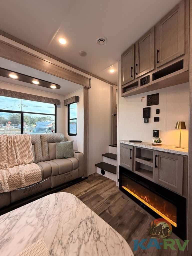 Electric fireplace and cozy seating in RV living space.