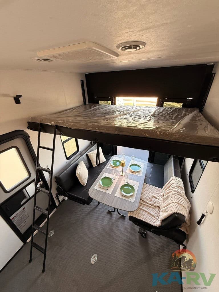 RV interior with sleeping loft and dining space for Dutchmen Voltage 3800.