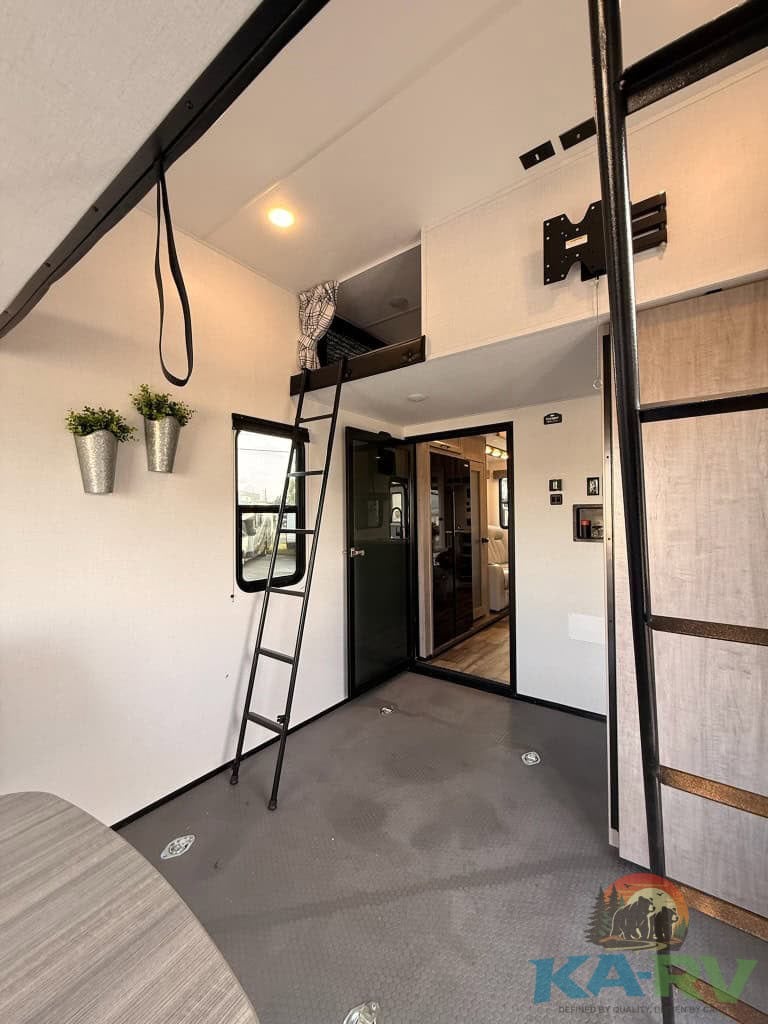Efficient RV interior with loft and sleek finishes for optimal travel experience.