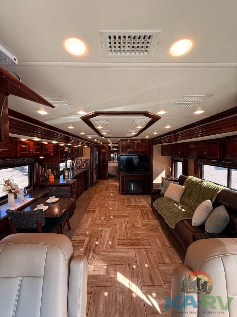 Comfortable RV living space with elegant wood cabinetry and plush seating for optimal travel comfort.