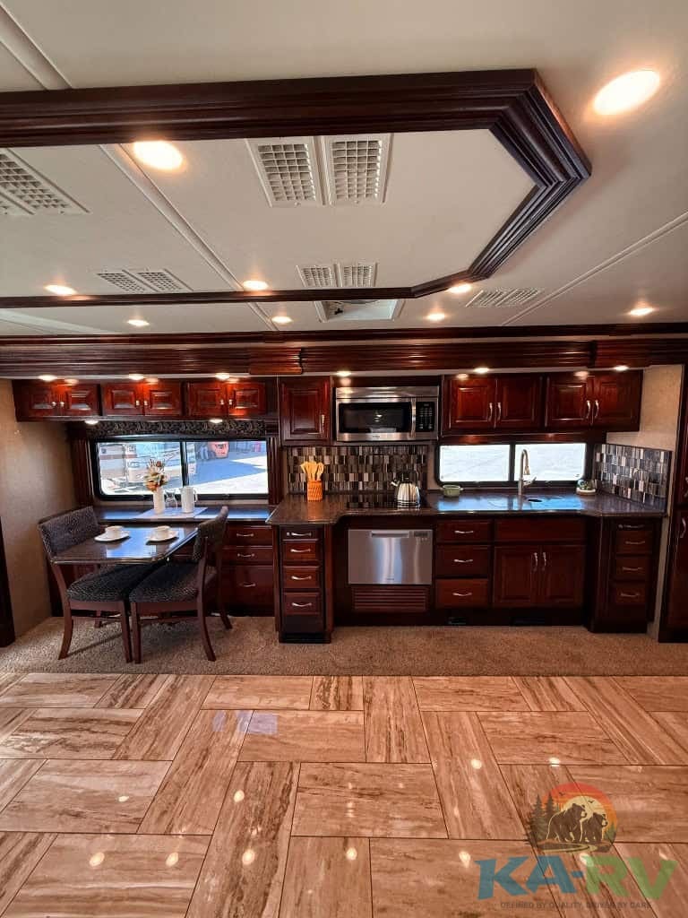 RV kitchen with dark wood cabinetry, stainless steel appliances, and ample counter space.