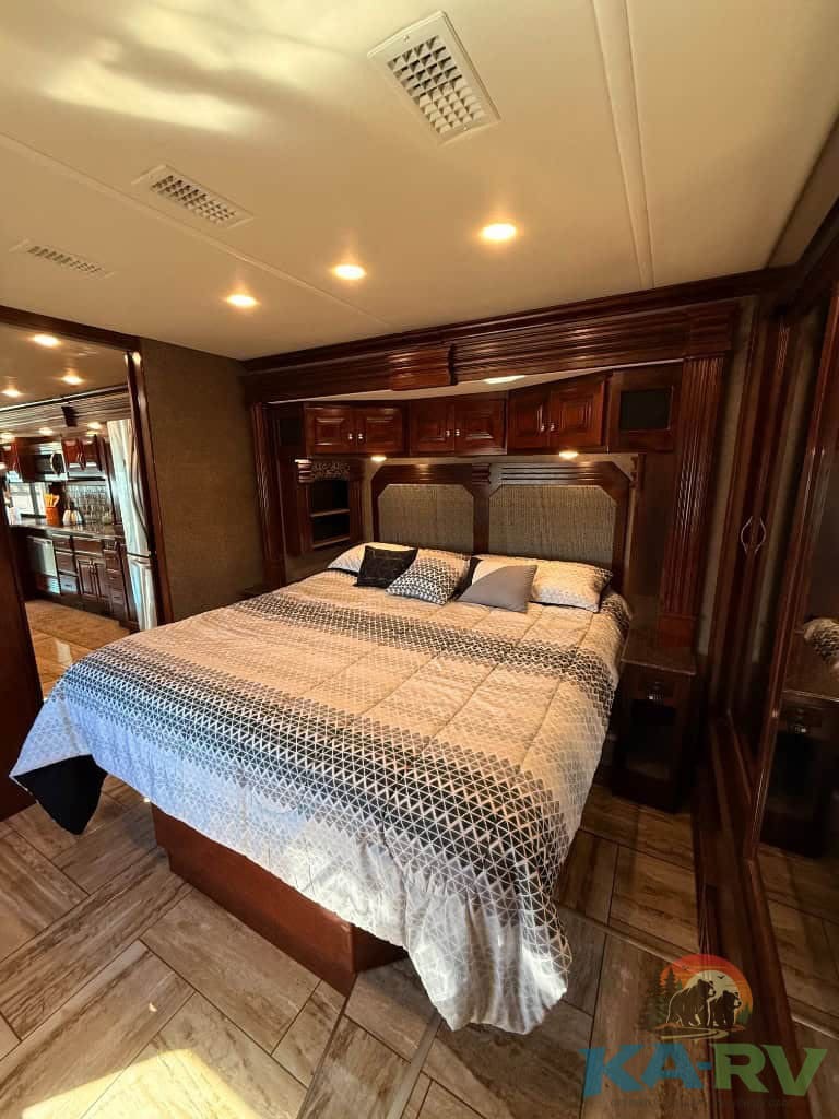 Elegant interior of a 2018 Fleetwood Discovery 39F RV bedroom with custom woodwork.