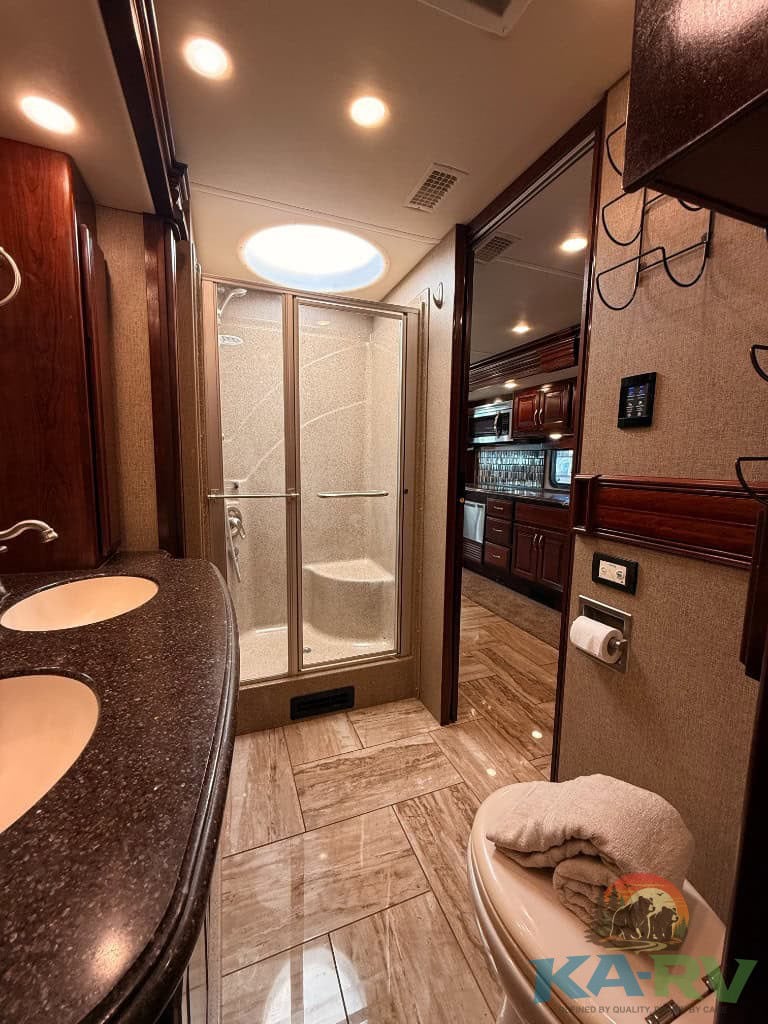RV bathroom with a shower, dual sinks, and modern fixtures.