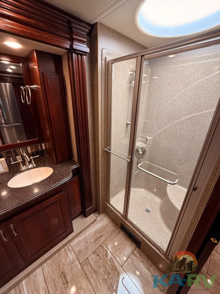 RV bathroom shower with safety grab bars in a 2018 Fleetwood Discovery 39F.