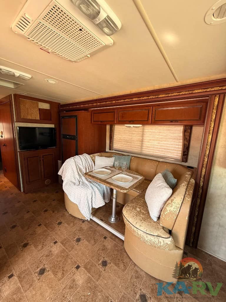 Interior view of a 2013 Four Winds Hurricane RV showing the dining area and cozy seating.