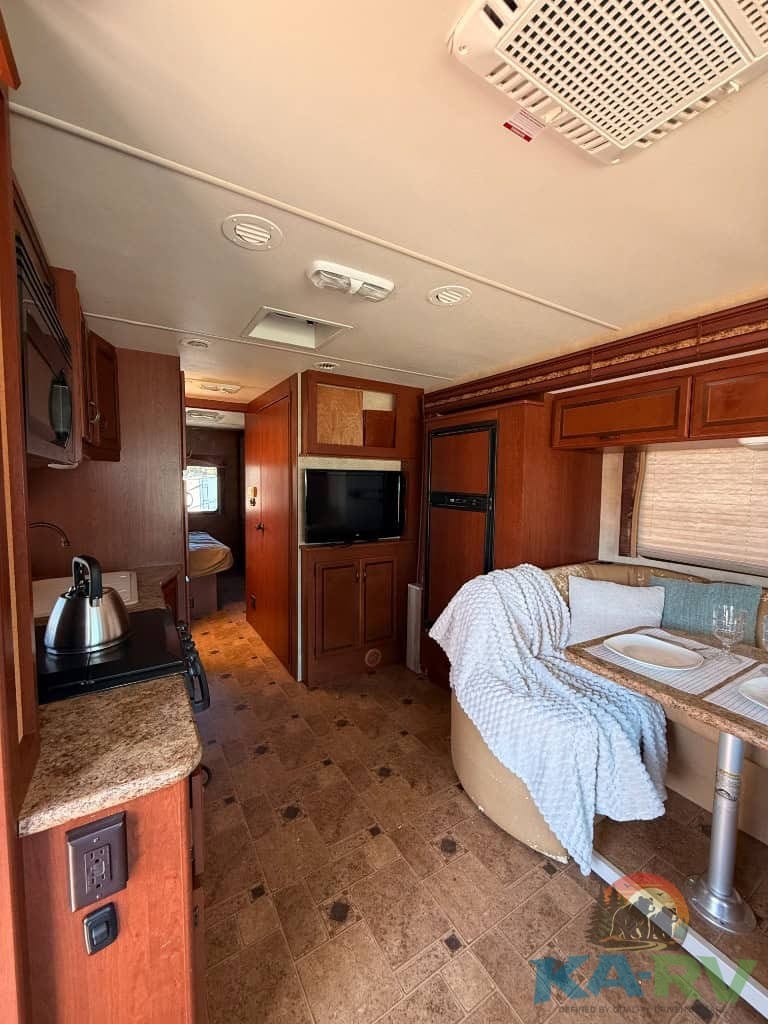 Comfortable RV living space with kitchen and seating area.