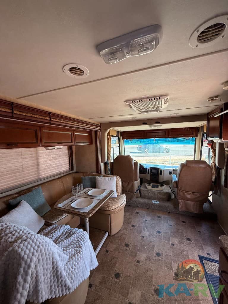 Comfortable RV interior of a 2013 Four Winds Hurricane with seating and dining area.