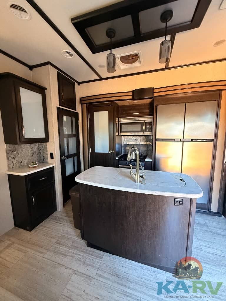 Luxury RV kitchen with modern cabinetry and appliances in a 2017 Grand Design Momentum 376TH.
