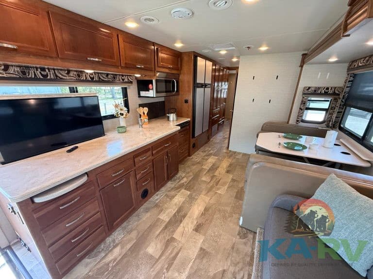 RV interior with wooden cabinetry and seating area, ideal for travel and camping.