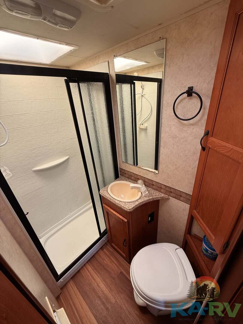 Compact RV bathroom with shower and sink.