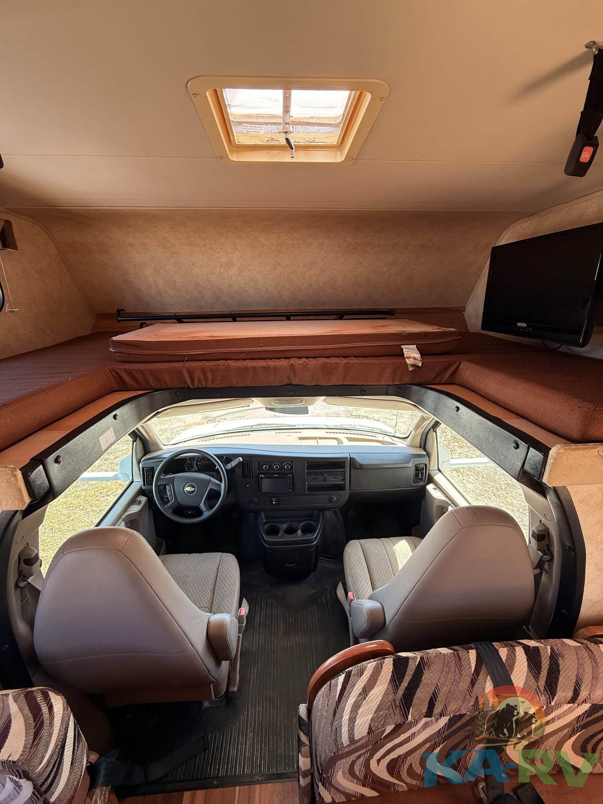 Interior view of a 2013 Coachmen Freelander 23CB RV dashboard and seating.