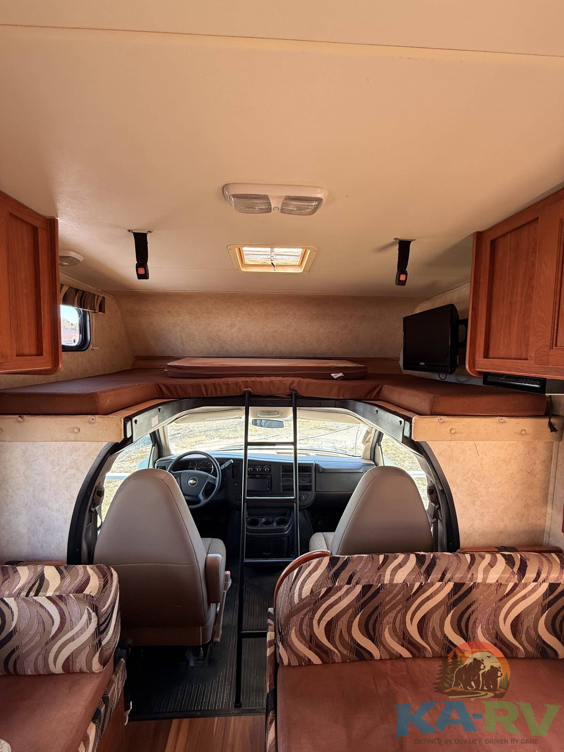 View of the driver's cabin and living area inside a 2013 Coachmen Freelander RV.