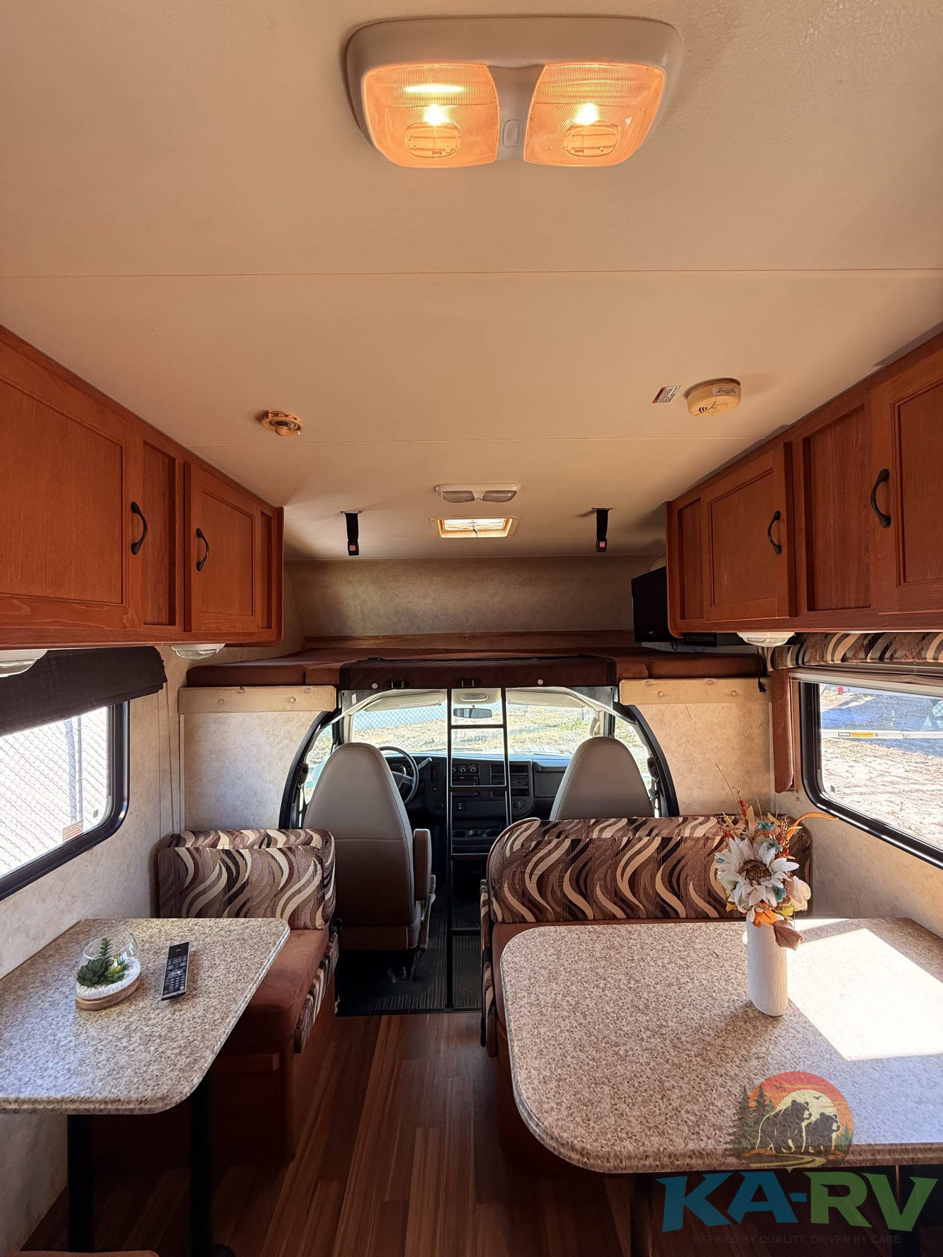 Interior view of a 2013 Coachmen Freelander RV showing seating and dashboard.