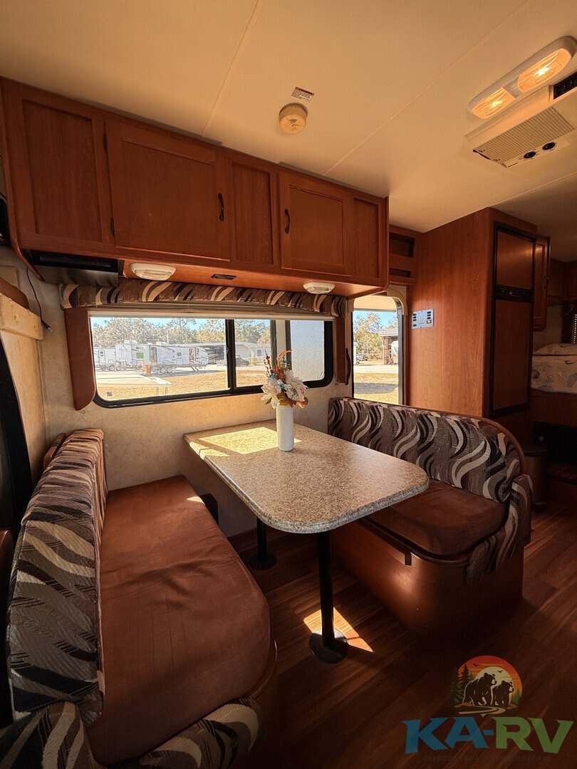 RV interior dining space with booth seating and a view.