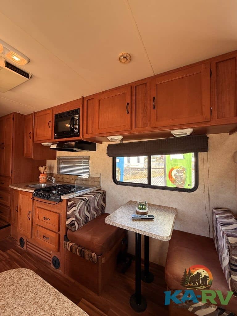Cozy RV kitchen and dining area in a 2013 Coachmen Freelander 23CB.