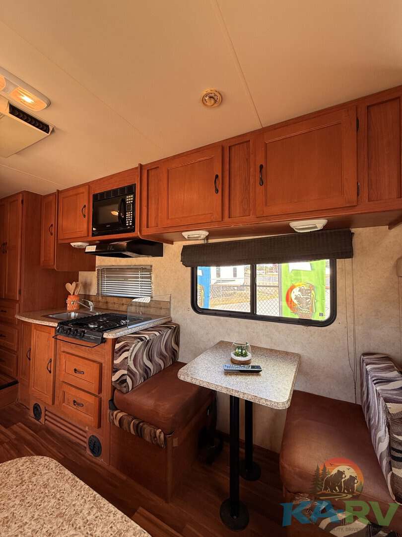 Cozy RV kitchen and dining area in a 2013 Coachmen Freelander 23CB.