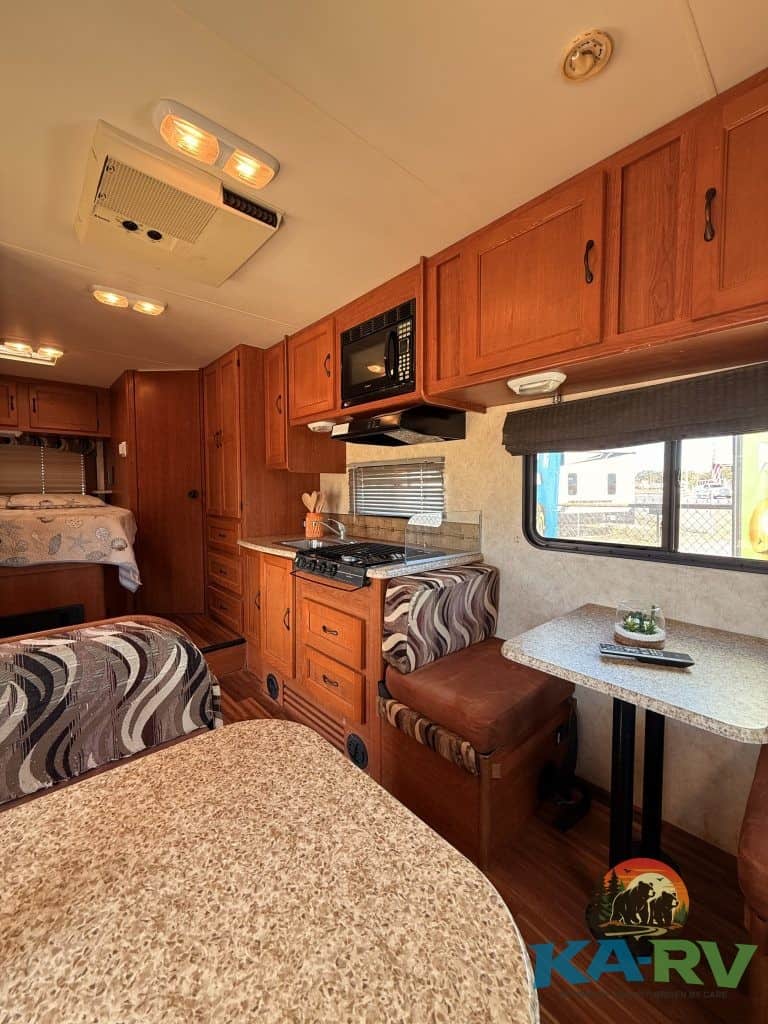 Interior view of a 2013 Coachmen Freelander 23CB RV kitchen and dining area.