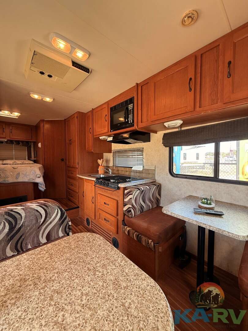 Interior view of a 2013 Coachmen Freelander 23CB RV kitchen and dining area.