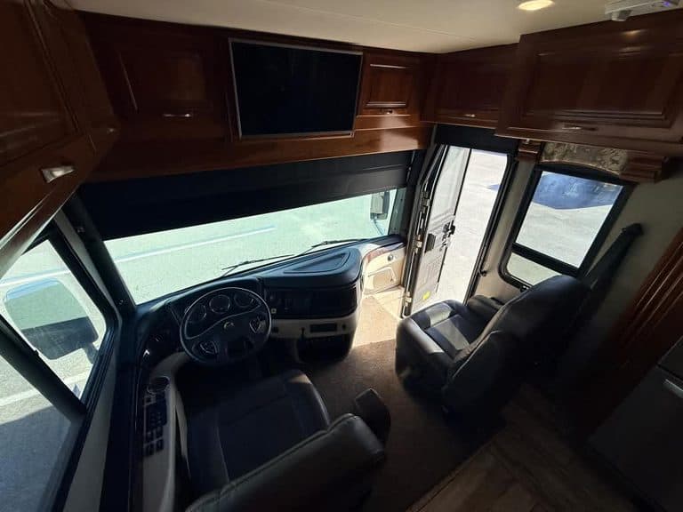 Interior view of a 2018 Fleetwood Discovery RV with dashboard and seating.