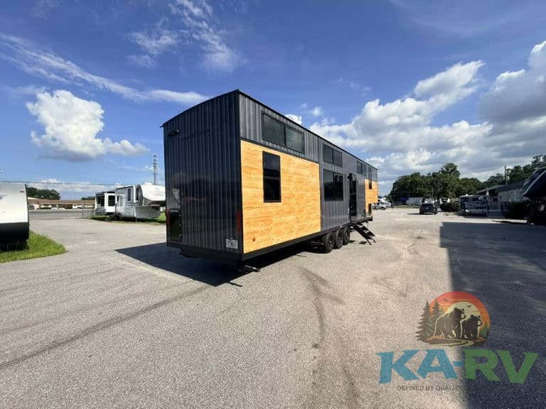 Cedar Creek Cottage 41 FWC RV with black and wood exterior in outdoor lot.