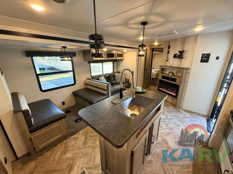 RV interior kitchen and living space with modern amenities and cozy seating.