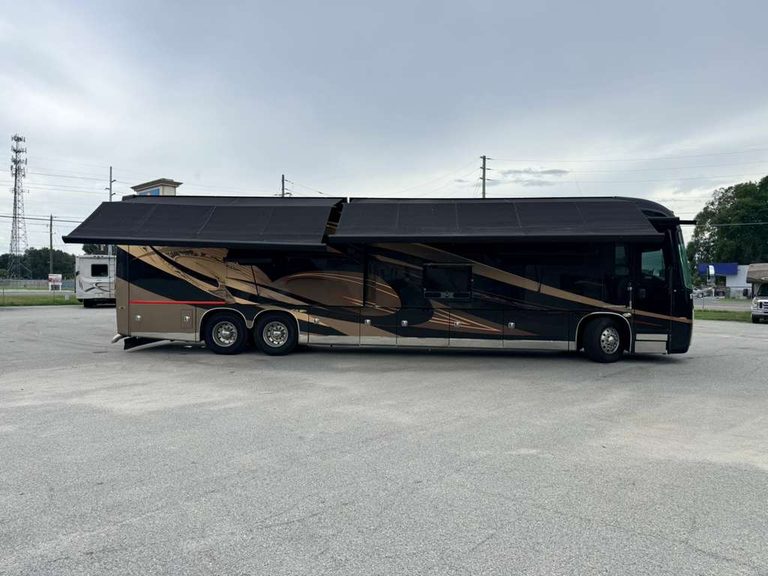 Black and gold luxury RV parked outdoors with KA RV Repair logo.