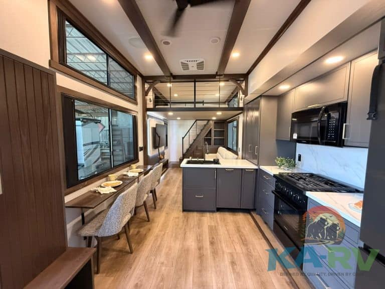 Contemporary kitchen with gray cabinets, black appliances, and large windows in Cedar Creek Cottage.